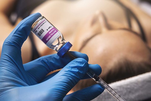 Gloved hand preparing a BOTOX injection