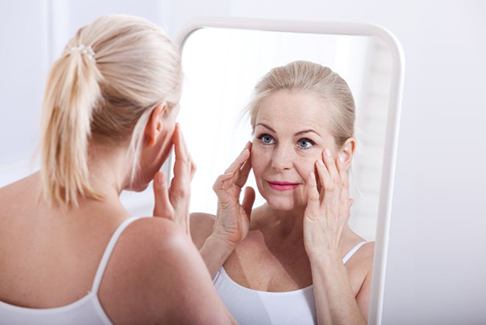 Mature woman looking at herself in mirror
